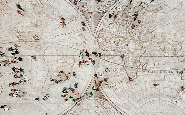 Aerial view of people walking over a floor with a world map design.