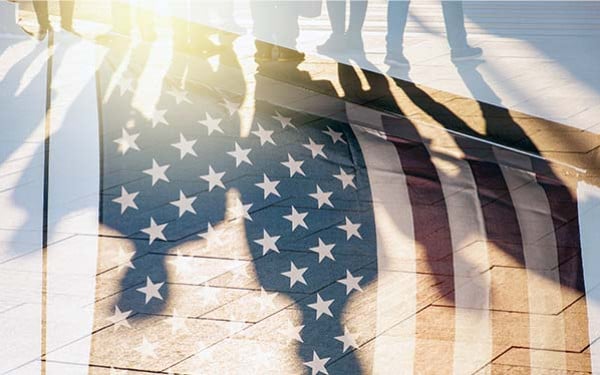 American flag overlayed with a reflection of people walking on a tiled floor.